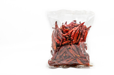 Dried chilli in cleared plastic packaging for sale on white background, front view of the dried...