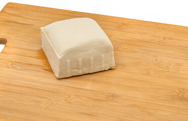Close up a firm Tofu on a wooden cutting board, white firm Tofu or medium firm Tofu with chubby shape, blank space for text. Details on the fresh Tofu
