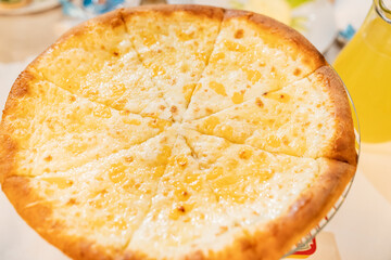 large pizza four cheeses on a metal stand for the festive table. traditional Italian cuisine. menu for the holiday. fast food and food delivery from cafes and restaurants.