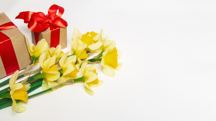 Bouquet of daffodils, gift box with red bow. Valentine's day, mother's day, birthday and spring concept for blogger with copy space