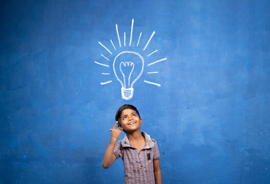 excited Kid with suddenly got or pop up idea expression under light doodle on blue background - concept of child found solution, creativity and brainstorm.