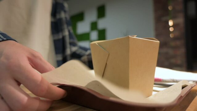 young man student in shirt and jersey taking his food order on tray with paper wok box container in slow motion