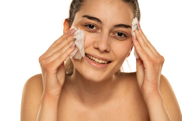 young happy young woman cleans her face with wet wipes