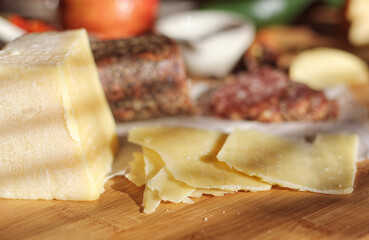 Peppercorn Salami on Tray With English and Irish Cheese, Sliced Apples and Spices in Rustic Kitchen