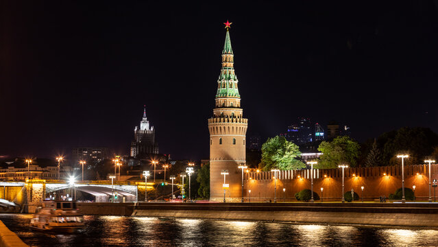Stadtansicht Moskaus mit der Moskwa sowie Br&uuml;cke im Vordergrund und dem beleuchteten Kreml samt Mauer, T&uuml;rmen sowie anderen Geb&auml;uden bei Nacht
