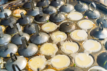 Vietnamese savory mini shrimp pancakes (Banh Khot) with herbs, eggs, shrimps and fish Sauce - Vietnamese cuisine.