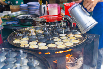 Vietnamese savory mini shrimp pancakes (Banh Khot) with herbs, eggs, shrimps and fish Sauce - Vietnamese cuisine.
