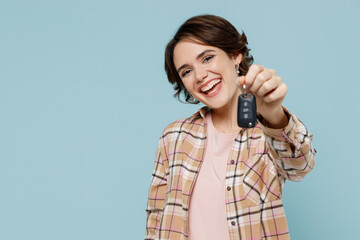 Young smiling happy cheerful woman 20s wearing casual brown shirt hold give car key fob keyless...