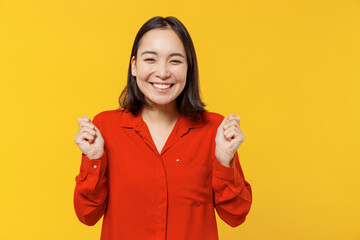 Charismatic jubilant excited young woman of Asian ethnicity 20s years old wears orange shirt doing...