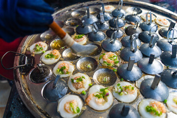 Vietnamese savory mini shrimp pancakes (Banh Khot) with herbs, eggs, shrimps and fish Sauce - Vietnamese cuisine.