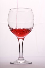 wine is poured into the glass against a white background