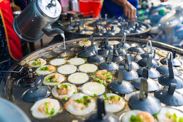 Vietnamese savory mini shrimp pancakes (Banh Khot) with herbs, eggs, shrimps and fish Sauce - Vietnamese cuisine.