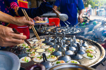 Vietnamese savory mini shrimp pancakes (Banh Khot) with herbs, eggs, shrimps and fish Sauce - Vietnamese cuisine.