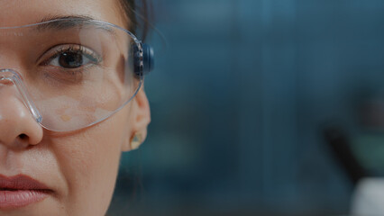 Woman scientist wearing protective glasses with virtual reality in science laboratory. Chemistry...