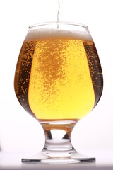 light beer pours into the glass against a white background