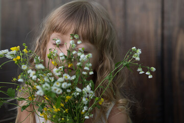 Naklejka premium the girl has closed her eyes and is holding a bouquet of flowers in her hands