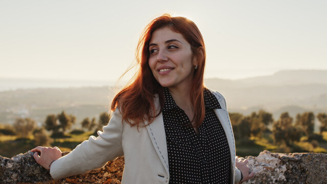 Beautiful girl with white dress explores an ancient Italian castle at sunset