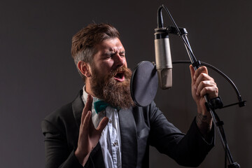 Singing man in a recording studio. Music festival. Expressive bearded man with microphone. Karaoke signer, musical vocalist.