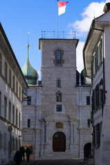 Flag of canton and city of Solothurn waving on top of stone tower at the medieval old town on a sunny winter day. Photo taken February 7th, 2022, Solothurn, Switzerland.