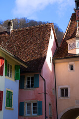 Beautiful historic houses with colorful facades at the little medieval town of St-Ursanne, Canton Jura, on a winter morning. Photo taken February 7th, 2022, Saint-Ursanne, Switzerland.