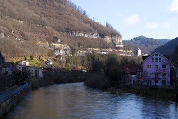 Obraz premium Close-up of river Doubs at little medieval old town St-Ursanne, Canton Jura, on a sunny winter day. Photo taken February 7th, 2022, Saint-Ursanne, Switzerland.