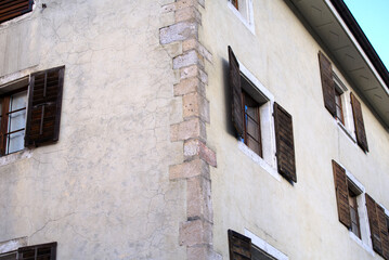 Window with wooden shutters at little medieval town St-Ursanne, Canton Jura, on a sunny winter morning. Photo taken February 7th, 2022, Saint-Ursanne, Switzerland.