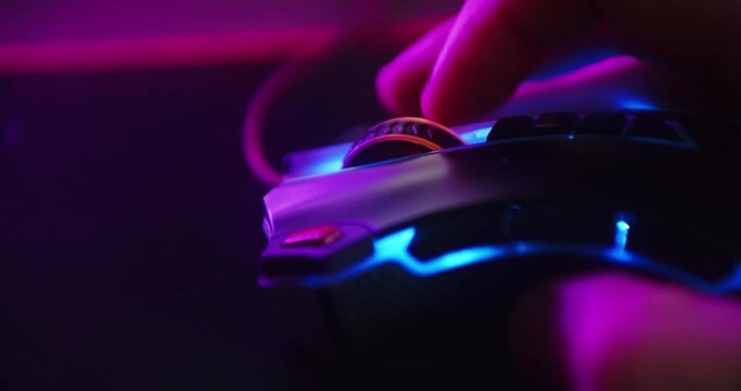 Close up shot of a hand scrolling the mouse wheel while playing games and clicking on a computer