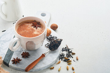 Masala tea. Masala chai spiced tea with milk and spices on light grey background. Traditional...