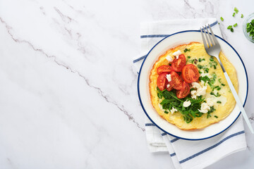 Breakfast fried eggs. Rustic omelette or frittatas with green onions, cheese mozzarella, green arugula and tomatoes on light stone background. Healthy food concept. Copy space. Top view. Mock up.