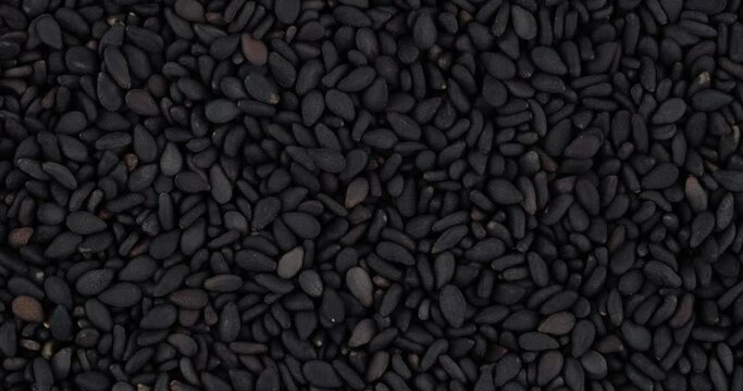 Top view of black sesame seeds rotating. Closeup. Macro.