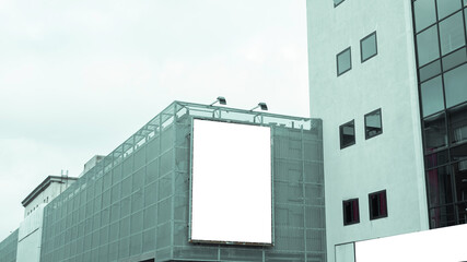 Isolated Blank White Mock Up Billboard With Copy Space in the Middle of the City on a Big Office Building.
