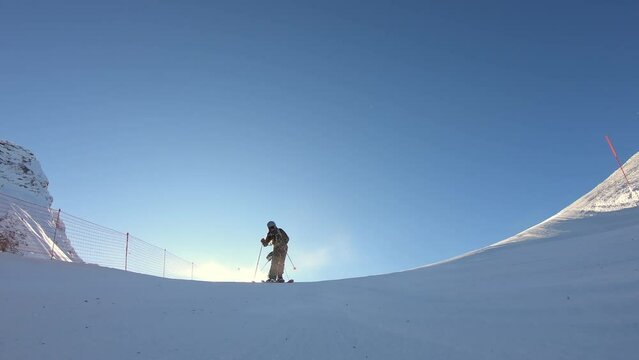 High speed ski turns on a steep ski slope in a glacier ski resort high up in the alps with fresh snow. Panorama skiing with the best mountain. Cinematic slow motion skiing in winter. 4K PRORES 422