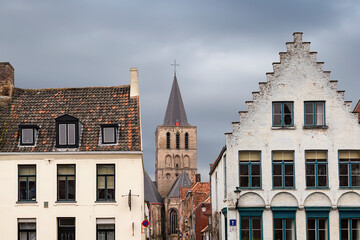Old traditional style buildings in in Historic city of Bruges with The Saint-Gillis church in the background