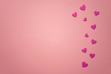 Magenta hearts on pink paper table. Copy space.