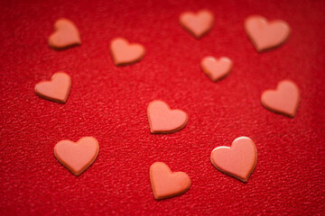 Fototapeta premium Lovely red hearts on red paper table. Art love card
