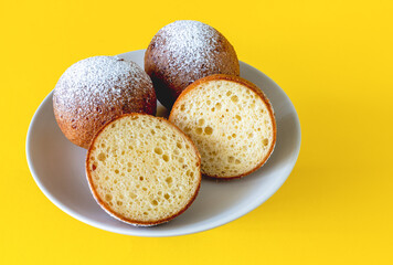 Lithuanian donuts on a plate on a yellow background