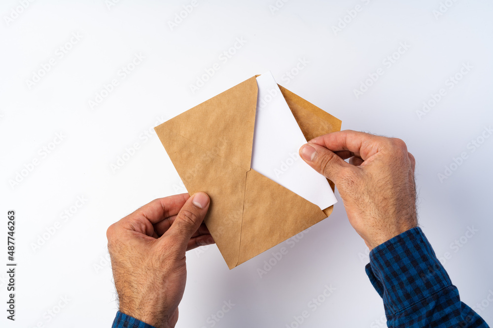 Poster Top view of male hands hold (open) an envelope above white background