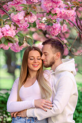 Fototapeta premium Wonderful flowering time of Japanese tree. Pink flowers around of woman and man.
