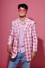 Fototapeta premium handsome guy in pink glasses pink blazer posing studio isolated background unaltered