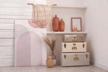 Stylish storage trunks and different decor elements near white wall indoors. Interior design