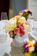 Beautiful bouquet of colorful flowers in a hat box on the dining table. 