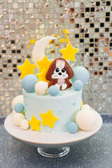 blue cake decorated with balls, stars and puppy made of mastic and chocolate.
