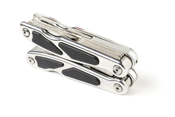 Stainless steel multi tool on white isolated surface. Selective focus. Top quality product for survival kit and outdoor adventure