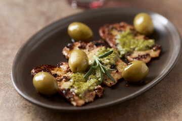 Fried pork with green olives and fresh rosemary. Close up. 