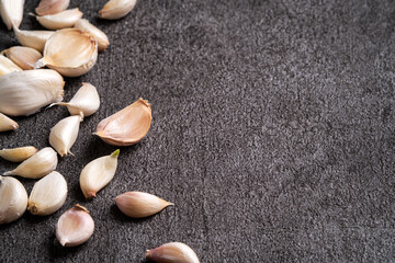 Fototapeta na wymiar Fresh garlic cloves on black table background.