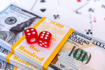 Big cash bet in casino and red dice with lucky number rolled. Playing dice lie on banknotes