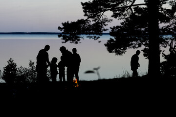 the family is relaxing in nature near the lake in the evening