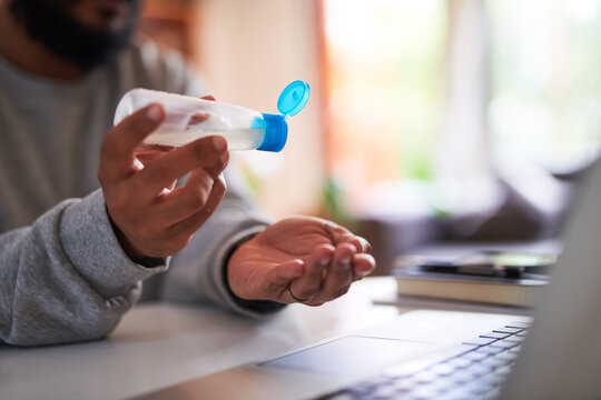 A man pours hand sanitiser onto his hands to keep them clean at the office