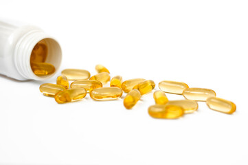 Omega-3 capsules lie in a jar (bottle) on a white background. Fish oil tablets. Biologically active...