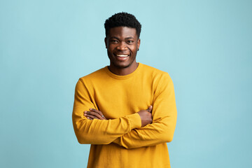 Handsome young black man posing alone on blue